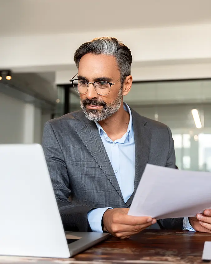 Businessman analyzing expenses on laptop with spend graph overlay