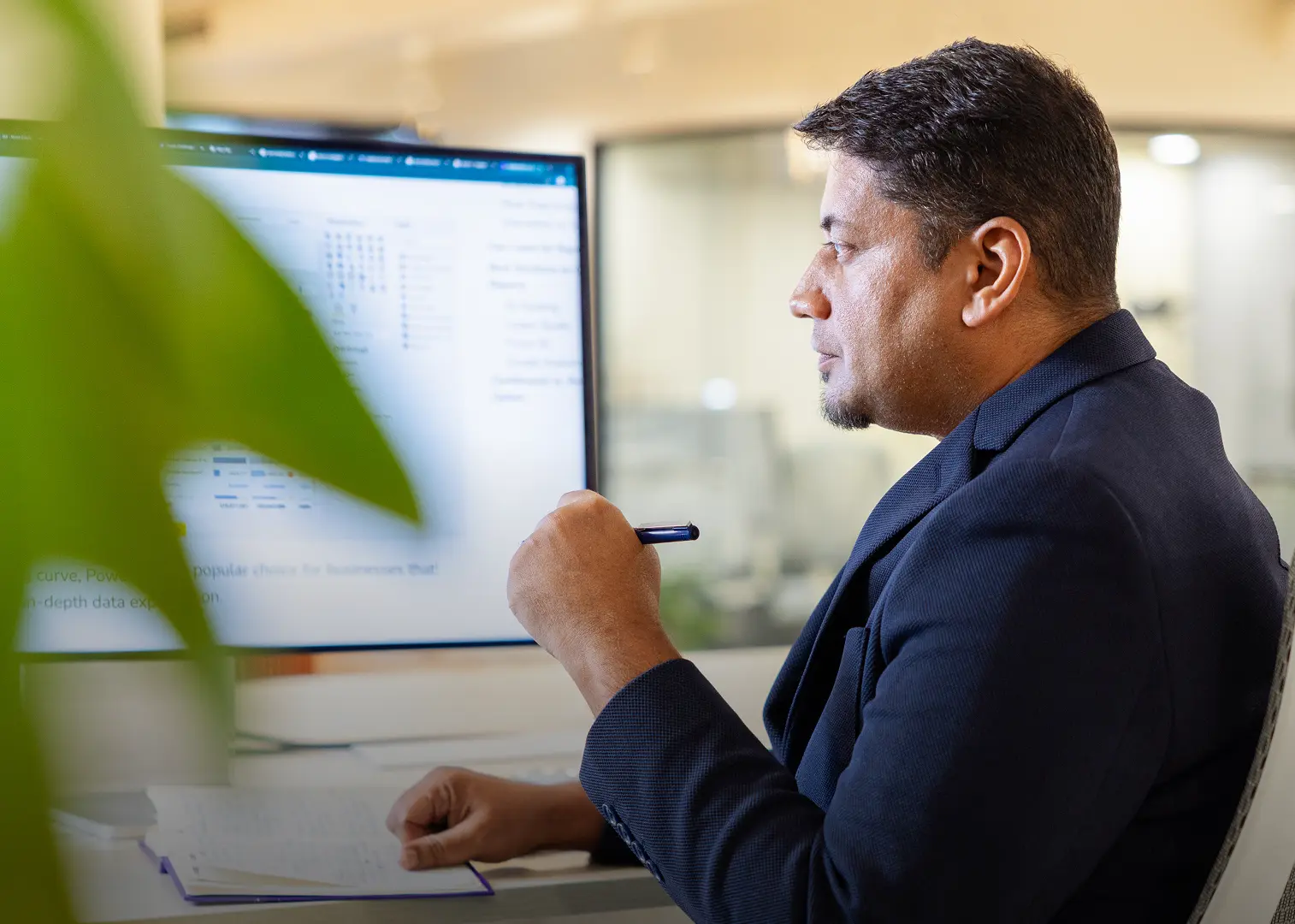 Professional man reviewing data on a computer screen in a modern office
