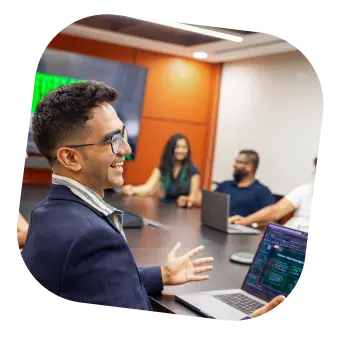 Pine Labs team members in a conference room engaged in a technology discussion with laptops