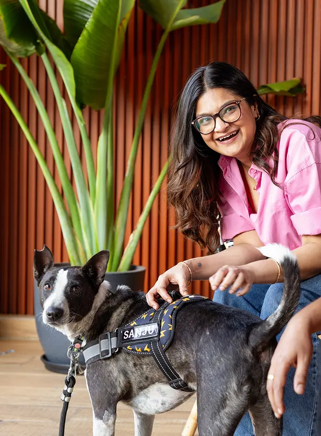 Woman smiling while petting a dog reflecting a balanced and engaging work culture